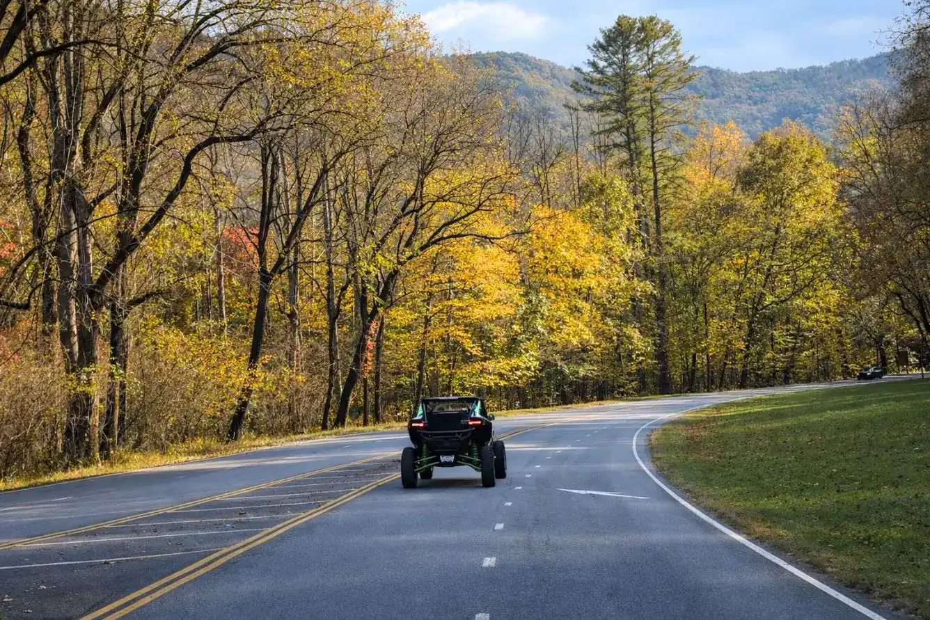 Street legal UTV navigating a scenic drive in the Smoky Mountains with mountain ridges in the background.