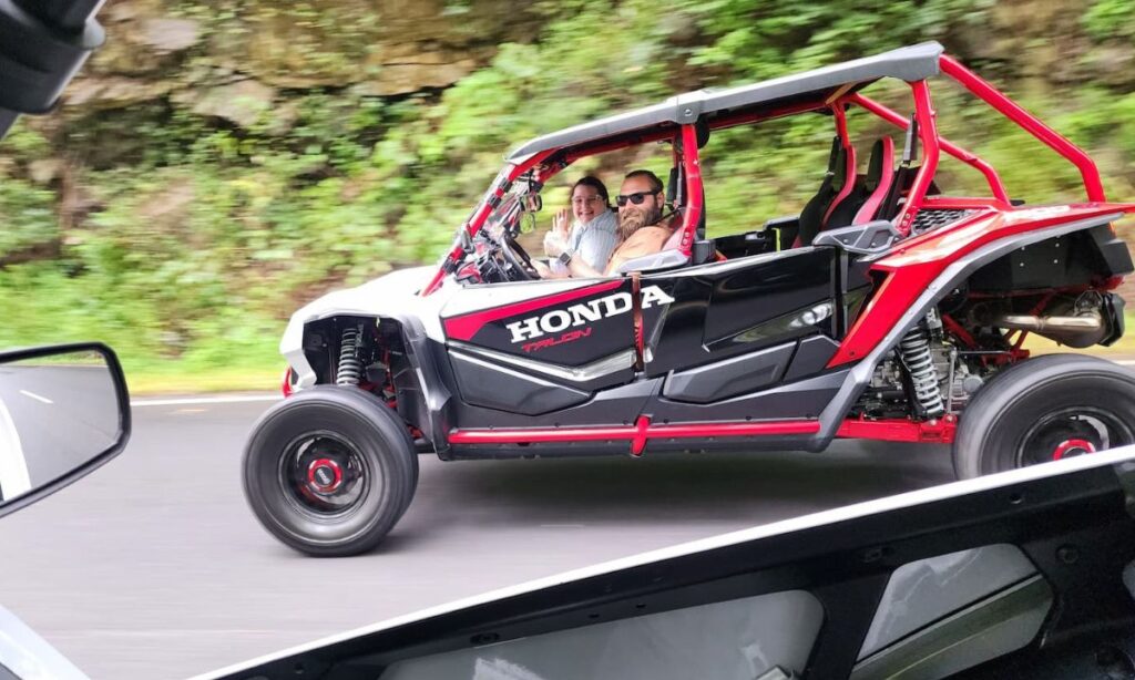 Couple smiling while driving a Honda Talon UTV rental through the Smoky Mountains near Pigeon Forge