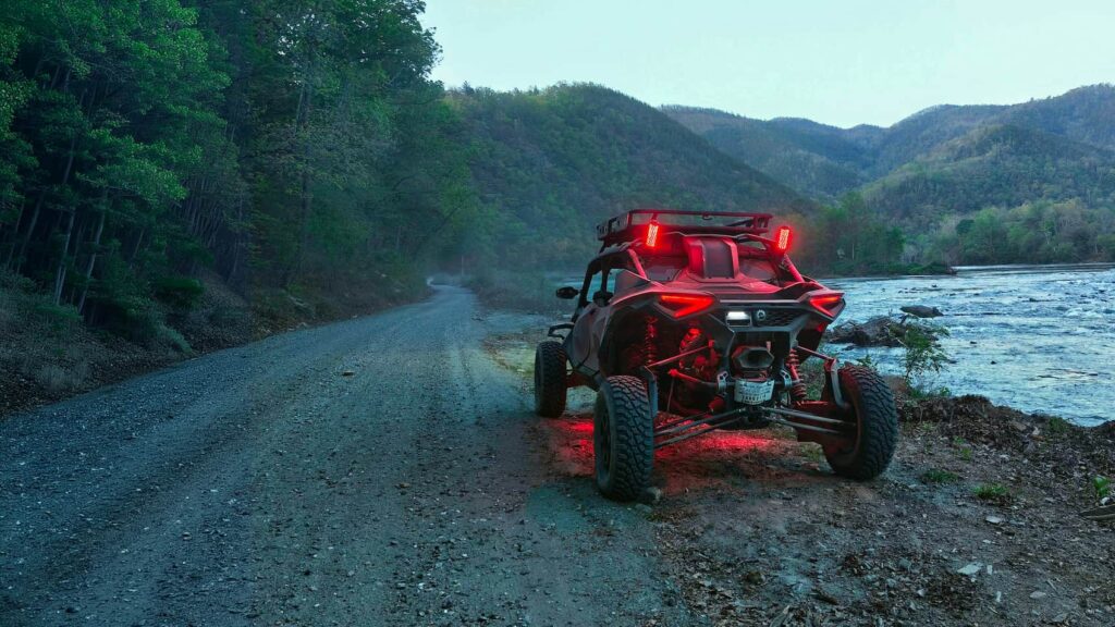 UTV rental in Pigeon Forge parked on a gravel trail along the river in the Smoky Mountains at dusk