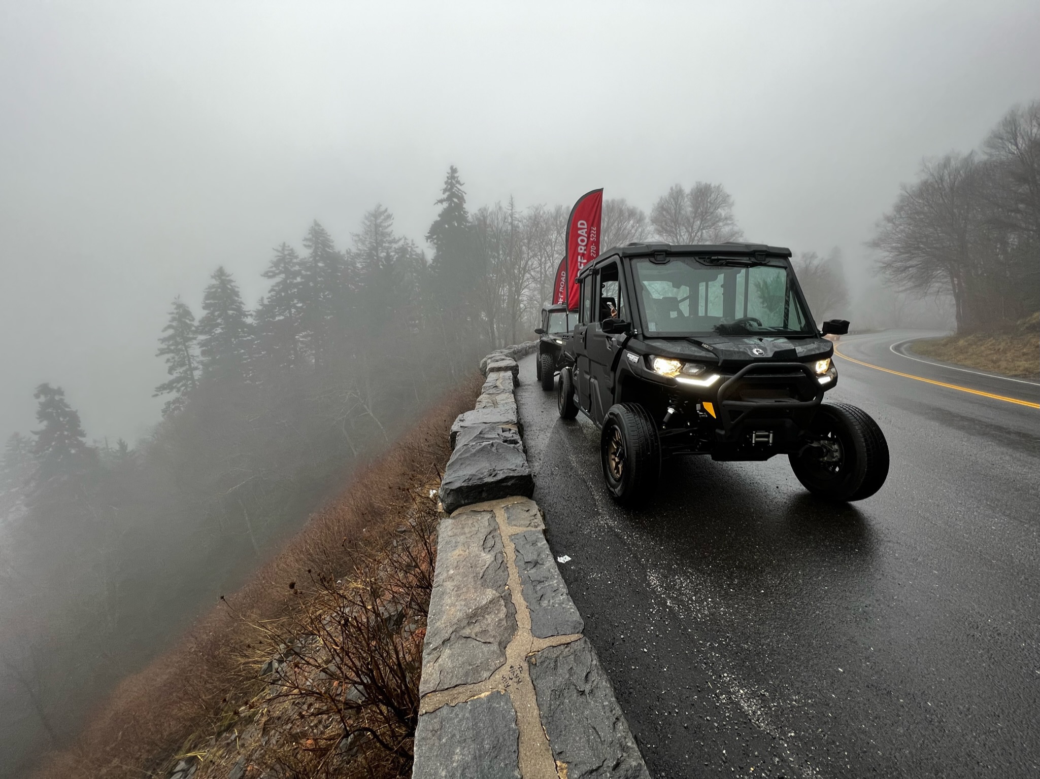 Enclosed Can-Am Defender UTV rental driving through rainy mountain roads in Pigeon Forge, TN